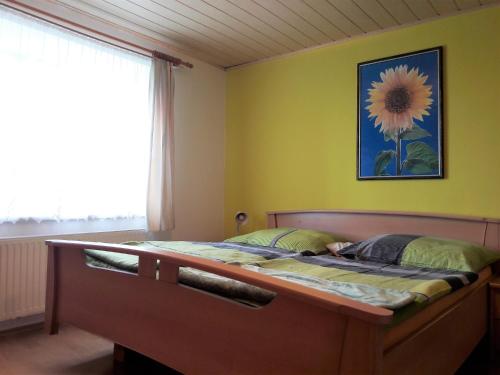 a bedroom with a bed with a flower picture on the wall at Helis Ranch in Ulrichsberg