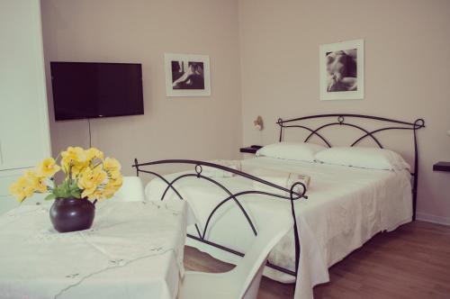 a bedroom with two beds and a table with yellow flowers at Casa Giulia in Cagliari