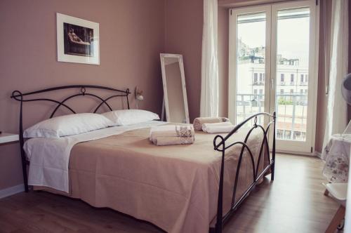 a bedroom with a bed and a large window at Casa Giulia in Cagliari