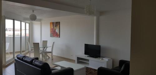 a living room with a couch and a tv at Hello Guyane 6, Appartement, Haut Standing in Cayenne