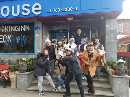 a group of people standing in front of a store at Gudeok Guesthouse in Seogwipo