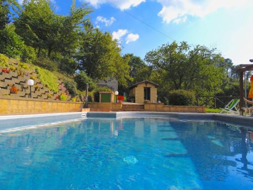 a large swimming pool with blue water in a yard at Cottage in Marche near Ski Slopes in Apecchio