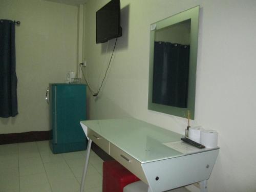 a bathroom with a white counter and a mirror at Pineapple Guesthouse in Karon Beach