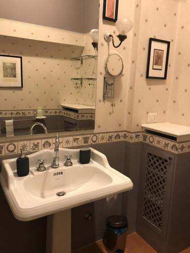 a bathroom with a white sink and a mirror at Luigi in Palazzo Bianchi in Parma