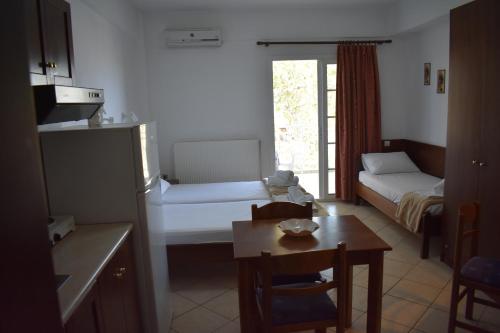a living room with a room with a table and a bed at Galanis Studios and Apartments in Platamonas