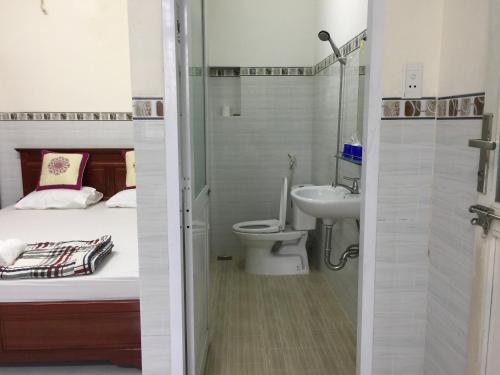 La salle de bains est pourvue d'un lit, de toilettes et d'un lavabo. dans l'établissement Hoang Oanh Motel, à Long Hải