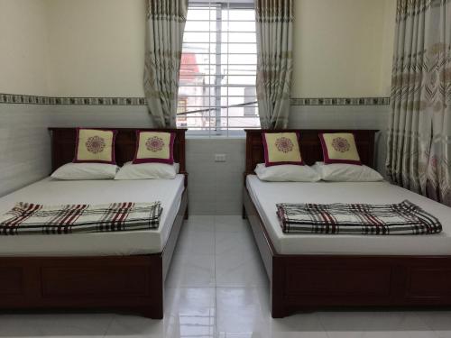Duas camas num quarto com uma janela em Hoang Oanh Motel em Long Hai