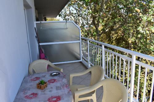 a balcony with a table and two chairs and a tree at Galanis Studios and Apartments in Platamonas