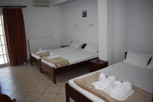 a room with two beds with towels on them at Galanis Studios and Apartments in Platamonas