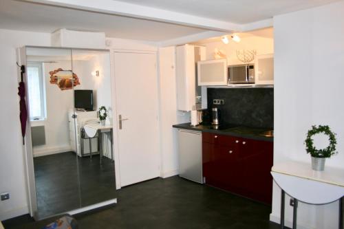 une cuisine avec des armoires blanches et un comptoir dans l'établissement Studio en plein coeur de Trouville, à Trouville-sur-Mer