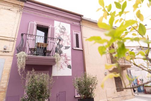um edifício roxo com uma janela e uma varanda em B&B Dei Poeti em Civitanova Marche
