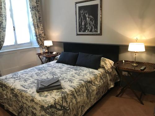 1 dormitorio con 1 cama y 1 mesa con lámparas en Luigi in Palazzo Bianchi en Parma