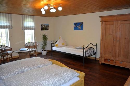 a bedroom with a bed and a table and chairs at Gutshaus Zietlitz in Dobbin