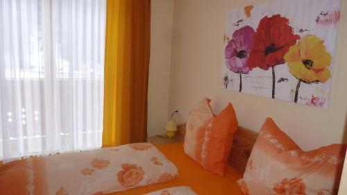 een slaapkamer met een bed met kussens en een raam bij Vronis Landhaus Apartments in Hüttau