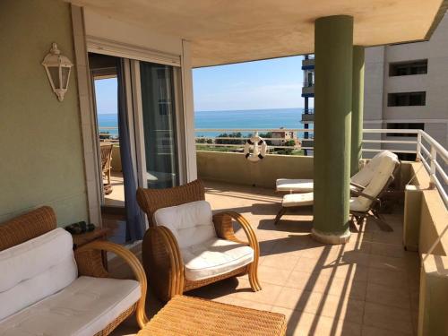 een balkon met stoelen en uitzicht op de oceaan bij Retiro Playa y Spa in Tavernes de la Valldigna