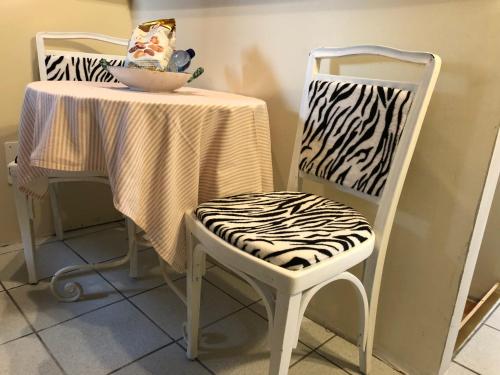 a table with a zebra print chair next to a table with a table cloth at Appartamento Country House Menaggio in Menaggio