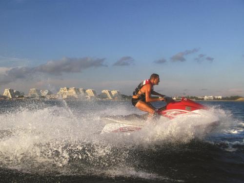 um homem a andar de jet ski na água em Vittoria Immobilier 10 -Vue Dégagée - Terrasse - chèques vacances acceptés em La Grande-Motte