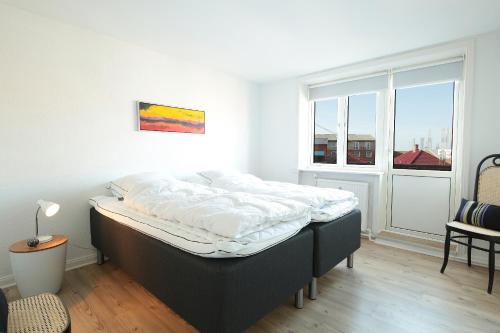 Cama en habitación con ventana grande en Marbækvej (ID 030), en Esbjerg