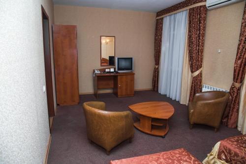 Habitación de hotel con mesa y TV en Safari Hotel Complex, en Samara