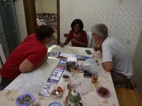 a group of three people sitting at a table at Kurak Homestay in Bishkek
