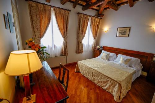 a bedroom with a bed and a table with a lamp at Hotel Riviera dei Dogi in Mira