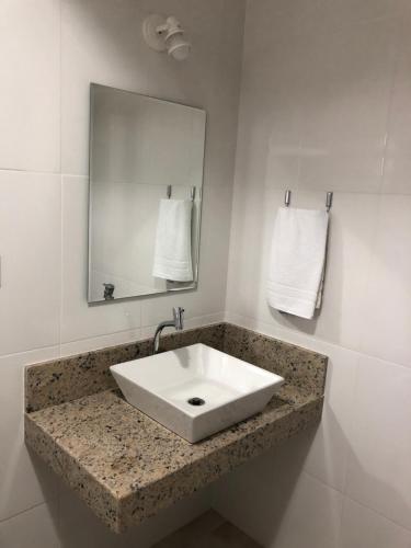 uma casa de banho com um lavatório branco e um espelho. em JP Palace Hotel em Saquarema