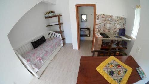 a small bedroom with a bed and a desk at Embaú Mar - ecocasa Morada Canto Verde - Guarda do Embaú SC - Brasil in Guarda do Embaú