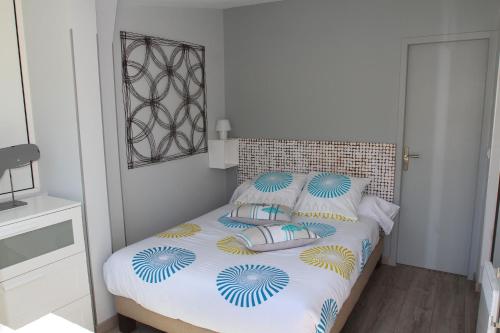 a bedroom with a bed with blue and yellow pillows at La Terrasse du Pecheur in Marseille