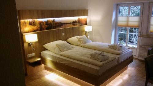 a bedroom with two beds and two lamps and a window at Hotel Weisser Hof in Malente