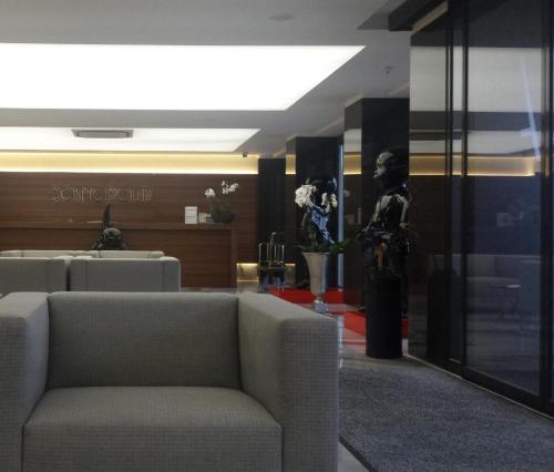 een lobby met een bank en een vrouw in een kamer bij Cosmopolita Hotel Boutique & Spa in Platja  d'Aro