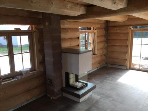 a fireplace in a room with wooden walls and windows at Chalet Karin in Hochfilzen