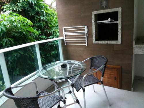 a glass table and two chairs on a balcony at Pousada Bora Bora in Bombinhas
