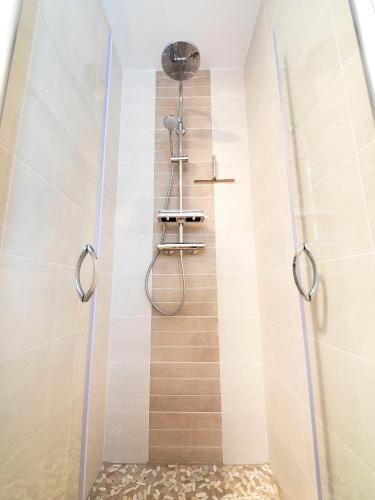 une douche avec une porte vitrée dans une salle de bain dans l'établissement Villa Quietude, à Bagnols-en-Forêt
