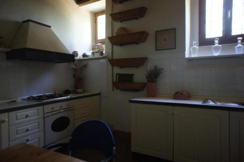 雷傑洛的住宿－Le Rose al Nibbio in Toscana，厨房配有水槽和炉灶 顶部烤箱