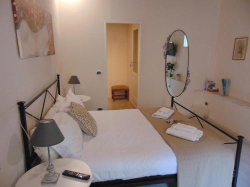 
a hotel room with a bed, mirror and a dresser at Bargello Guest House in Florence
