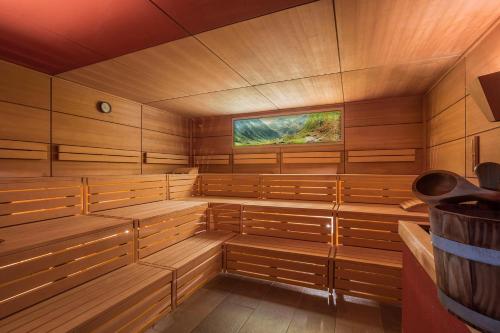 a sauna with wood paneling and a television at Alpen-Herz Romantik & Spa - Adults Only in Ladis