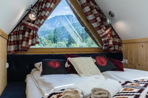 a bed in a room with a large window at Rezydencja Sobiczkowa Apartamenty in Zakopane