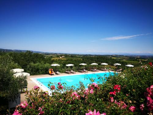 a swimming pool with chairs and umbrellas at Castello di Fulignano Soarzio panoramic apartment in San Gimignano
