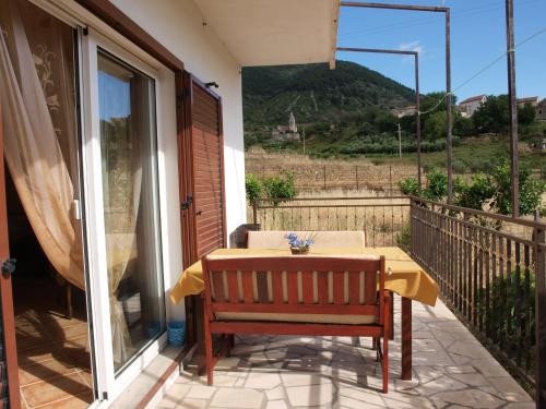 a table and a chair on a balcony with a view at Apartments Popaj in Komiža