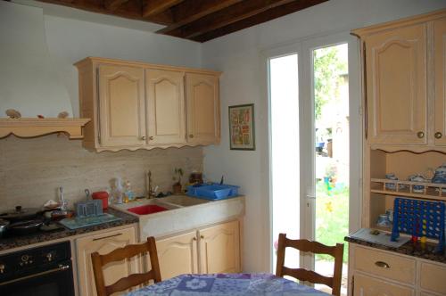 a kitchen with wooden cabinets and a sink and a table at Le Coffret d'avenir in Saint-Denis-en-Val