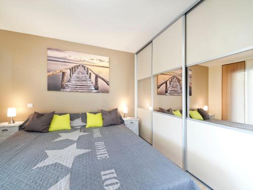 バニョル・アン・フォレにあるAppartement Villa Quietudeのベッドルーム1室(大型ベッド1台、黄色い枕付)