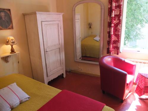 - une chambre avec un miroir, un lit et une chaise dans l'établissement Arles Bienvenue, à Arles