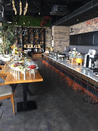 a restaurant with a long line of tables with food at Wes Hotel in Kocaeli