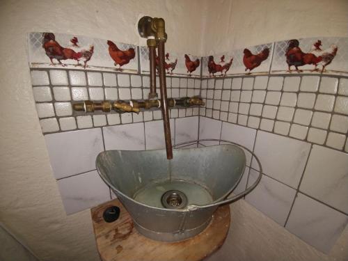 a bathroom with a bowl with chickens on the wall at Die Hoenderhok and Die Plaashuisie in Swellendam