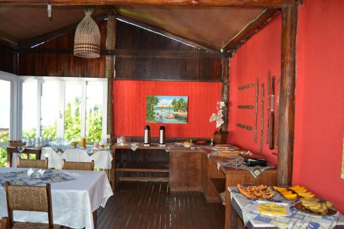 una cucina con pareti rosse e un tavolo con il cibo di Pousada Corumbau a Corumbau