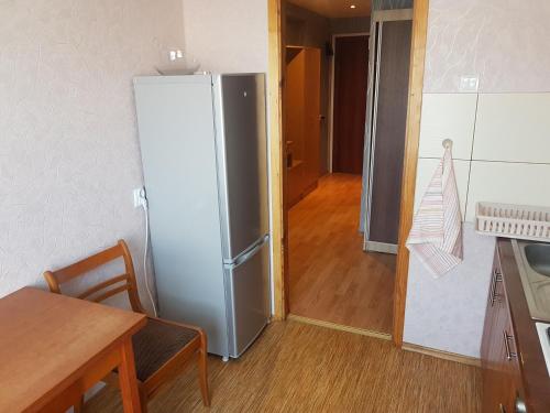 una cucina con frigorifero in acciaio inox e tavolo di Apartamenti Auseklis a Valmiera