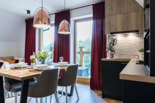 a kitchen and dining room with a table and chairs at Rezydencja Sobiczkowa Apartamenty in Zakopane