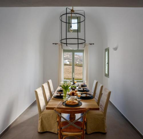 una sala da pranzo con tavolo e sedie in legno di Samsara Private Villas a Megalochori