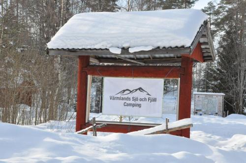 a sign with snow on top of it in the snow at Stuga 5 Varmland in Torsby