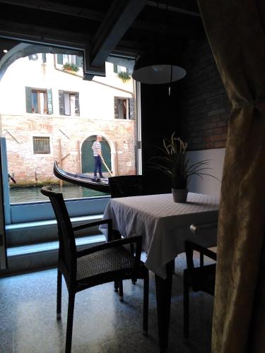 a room with a table and chairs and a person on a boat at Casa Marco Polo in Venice